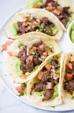 Angled photo of steak tacos with veggie toppings.