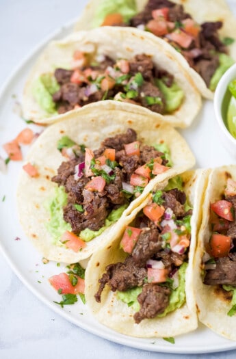 Angled photo of steak tacos with veggie toppings.