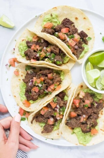 Plate of tacos with veggie toppings.