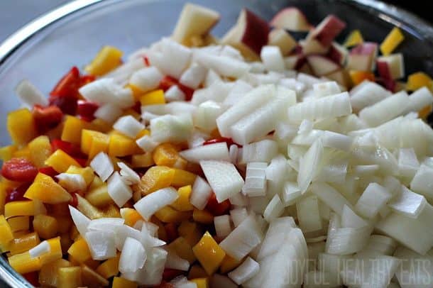 Diced bell pepper, onion, and red potatoes in a mixing bowl