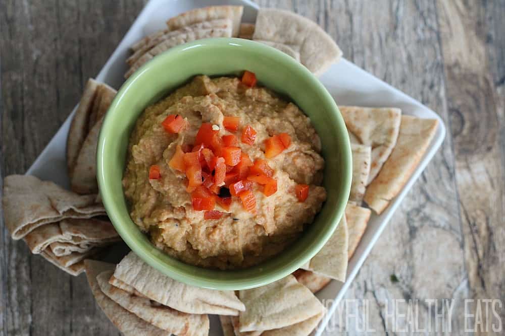 A bowl of hummus with red peppers