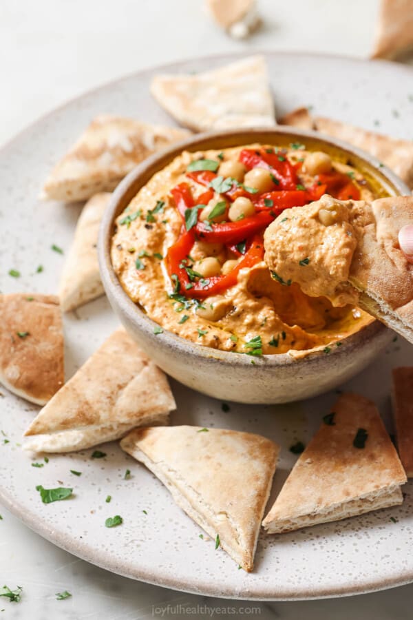 Dipping a pita chip into the chickpea dip.