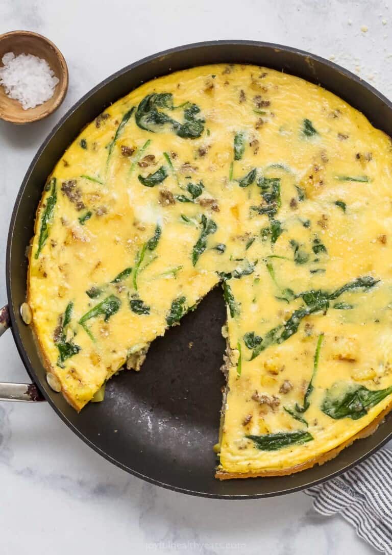 Potato frittata in the skillet with a missing slice.