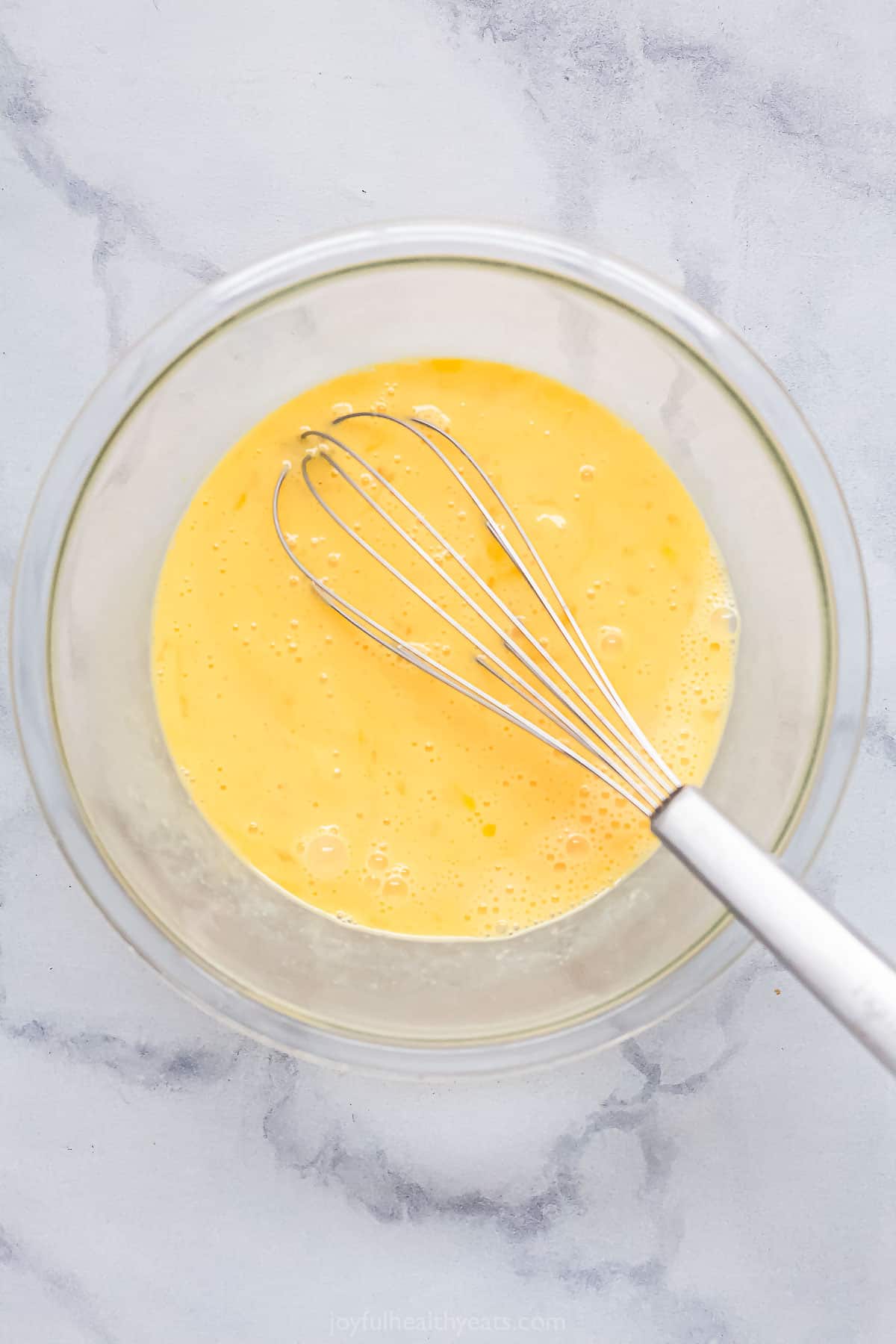 Whisking the egg mixture in a bowl. 