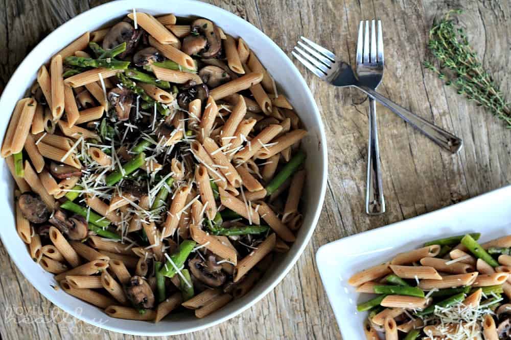 Asparagus & Mushroom Pasta topped with shredded cheese in a serving bowl