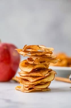Stack of baked apple chips on countertop