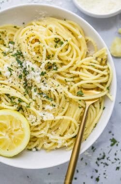 Lemon garlic pasta twirled around fork set in bowl