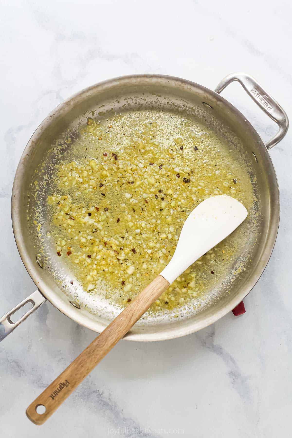 This Lemon Garlic Pasta is a 15-minute dinner elevated enough for a date night, but it's made with a short and simple list of ingredients! Lemon garlic sauce cooking in skillet