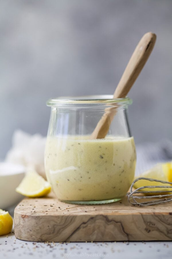 Jar of homemade Caesar salad dressing with spoon.