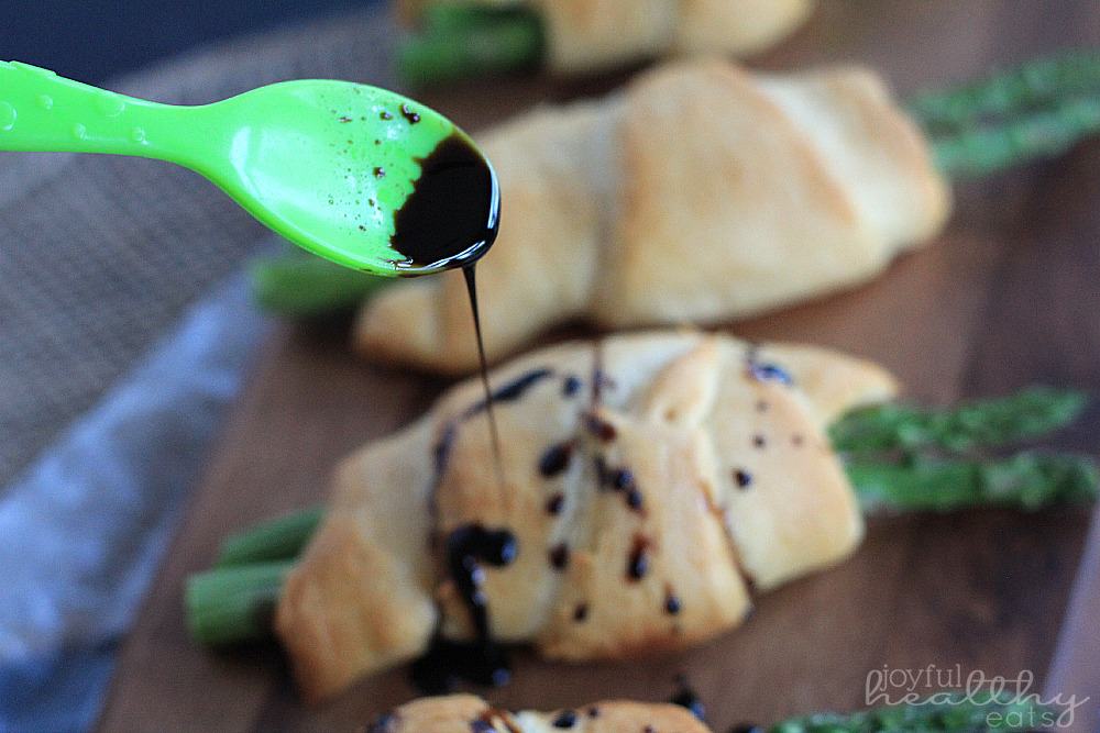 An Asparagus Rollup Being Drizzled with Balsamic Reduction