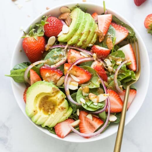 Bowl of salad with lots of strawberries and avocado.