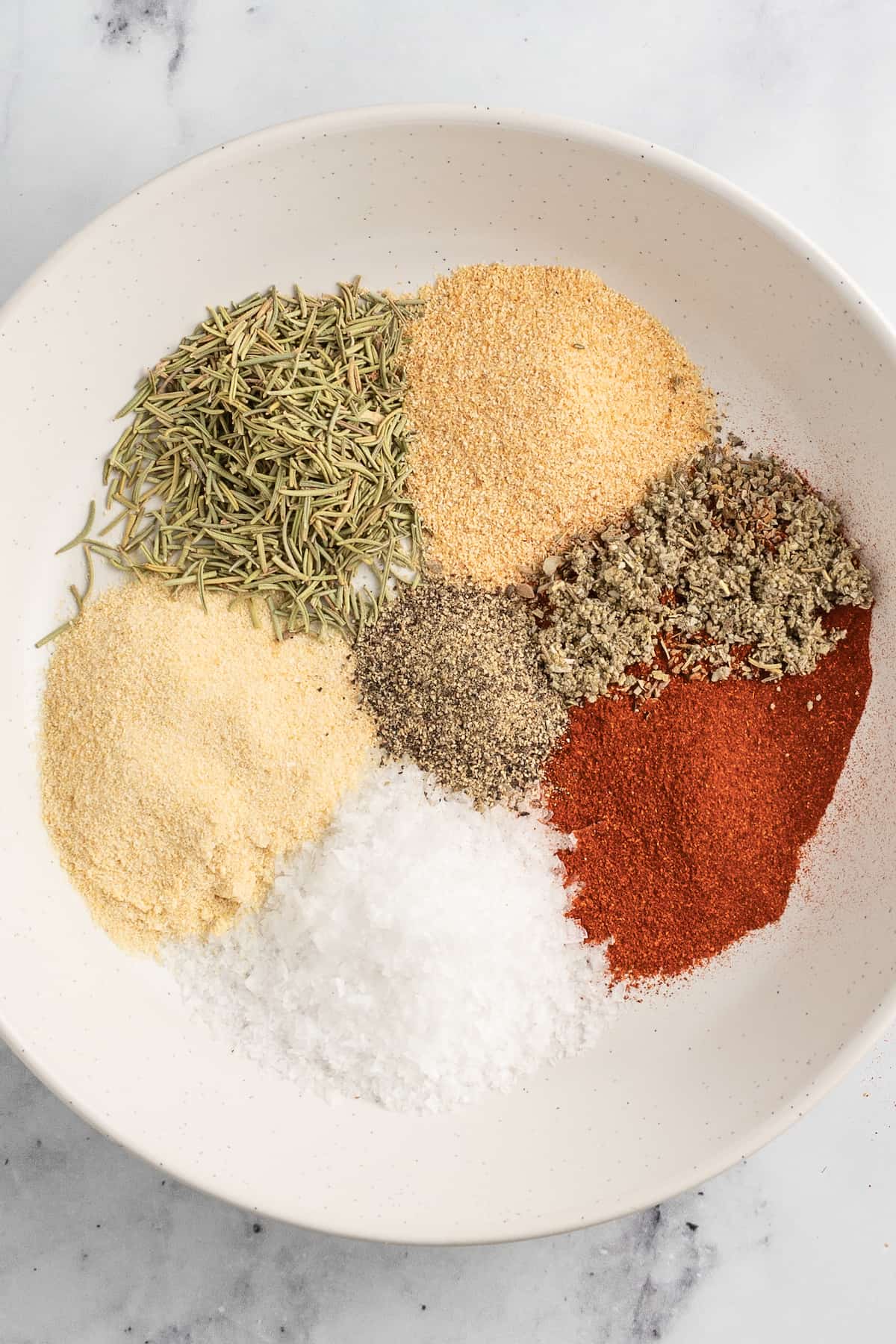 an assortment of dried spices seperated in a small bowl