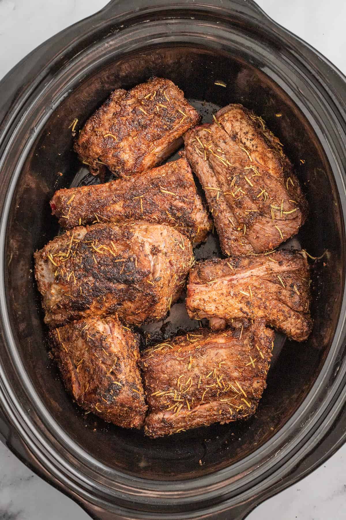 seared short ribs in a slow cooker pot