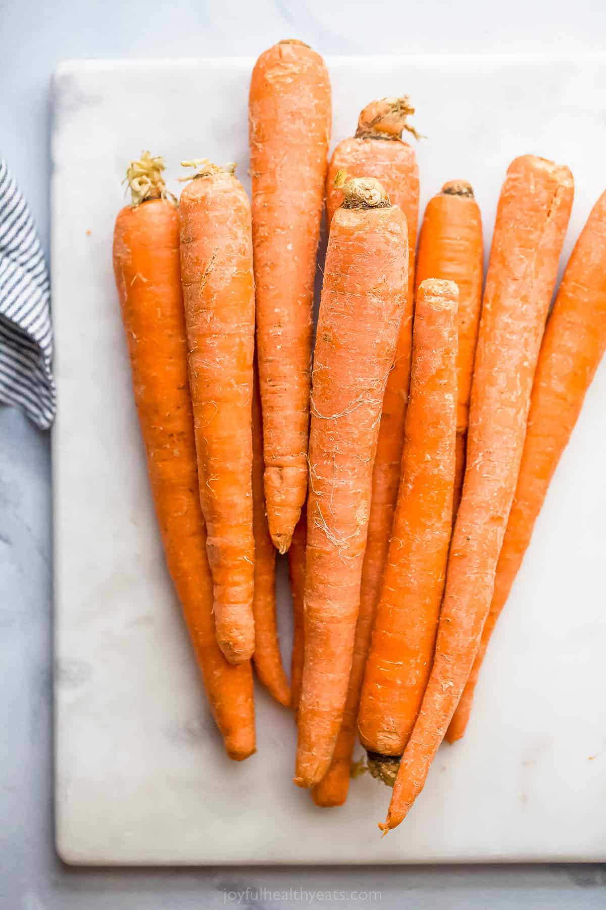 raw whole carrots on a cutting board