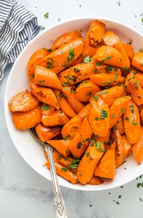 a white plate with glazed and roasted carrots