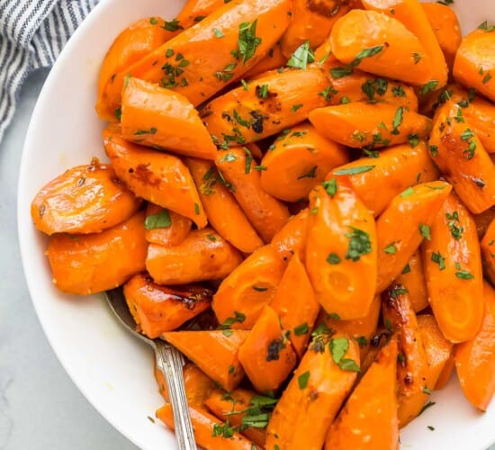 a white plate with glazed and roasted carrots