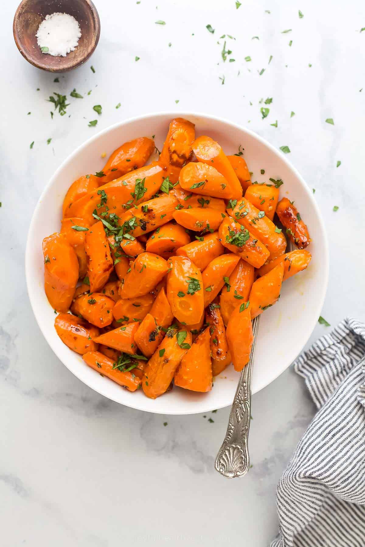 a white plate with glazed and roasted carrots