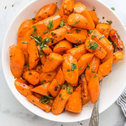 a white plate with glazed and roasted carrots