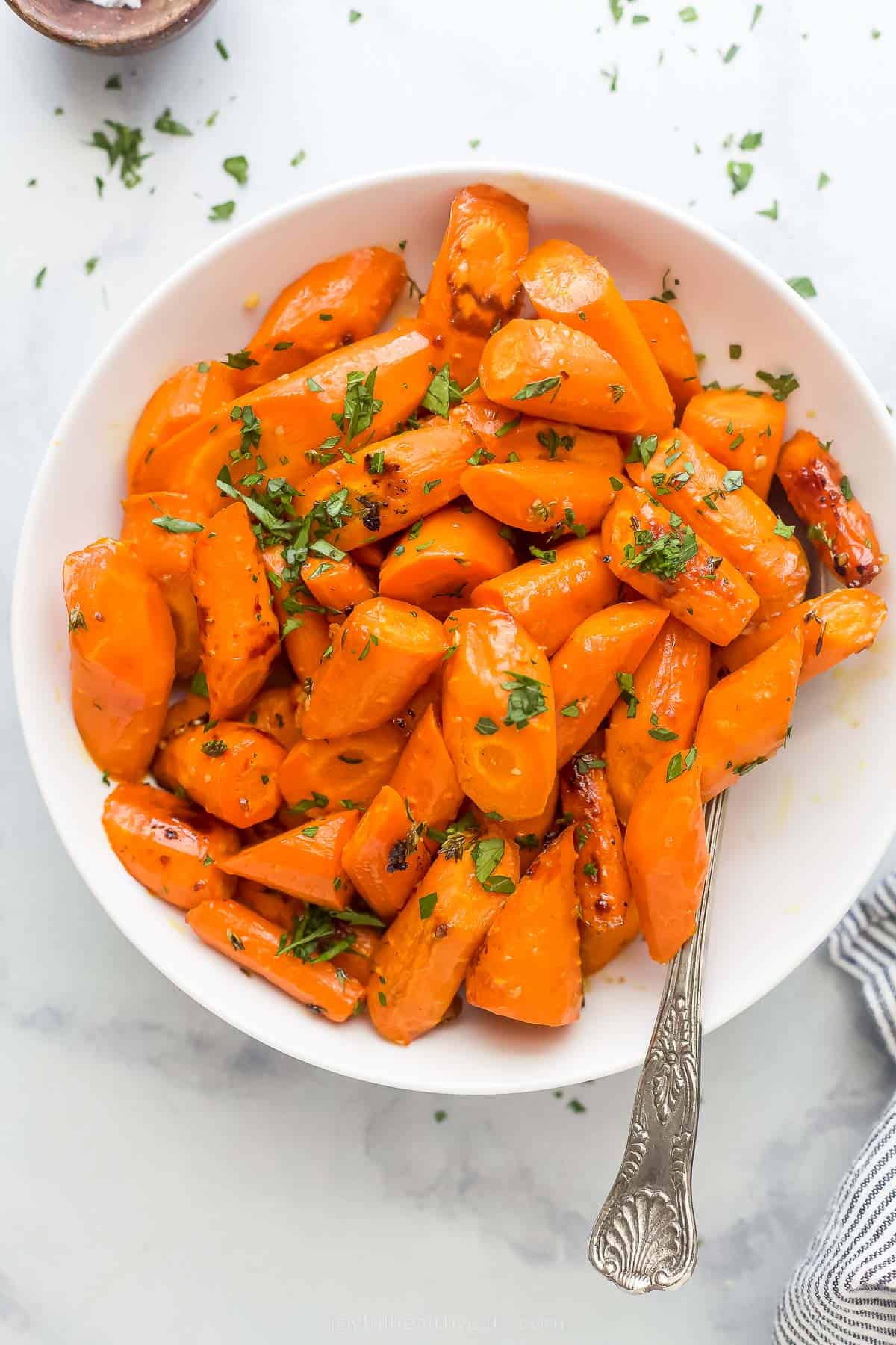 a white plate with glazed and roasted carrots