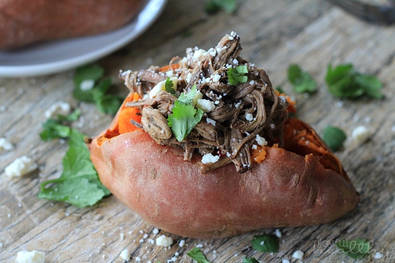 Chipotle Beef Barbacoa Stuffed Sweet Potato on a wooden board