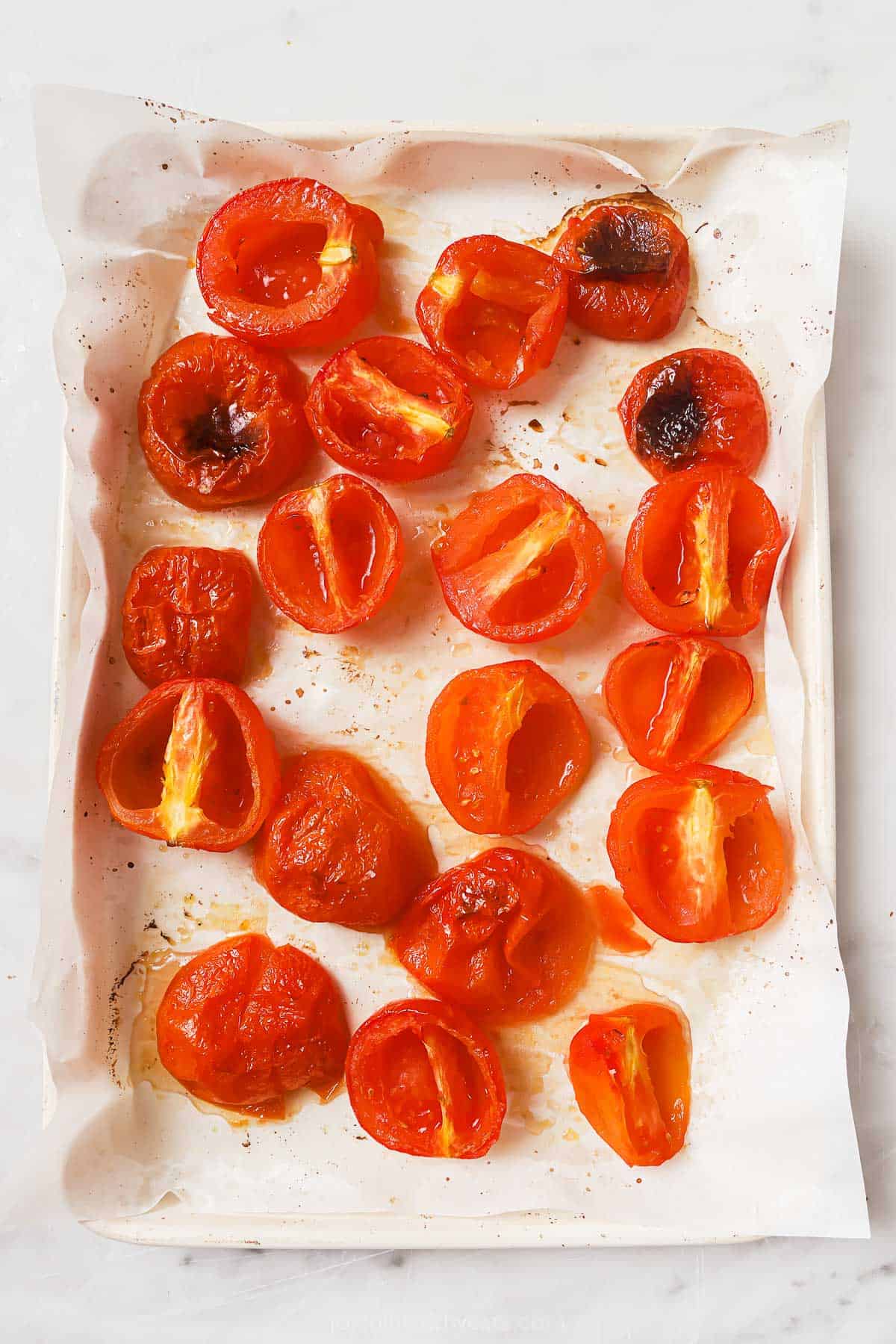 Roasted tomatoes on the baking sheet. 