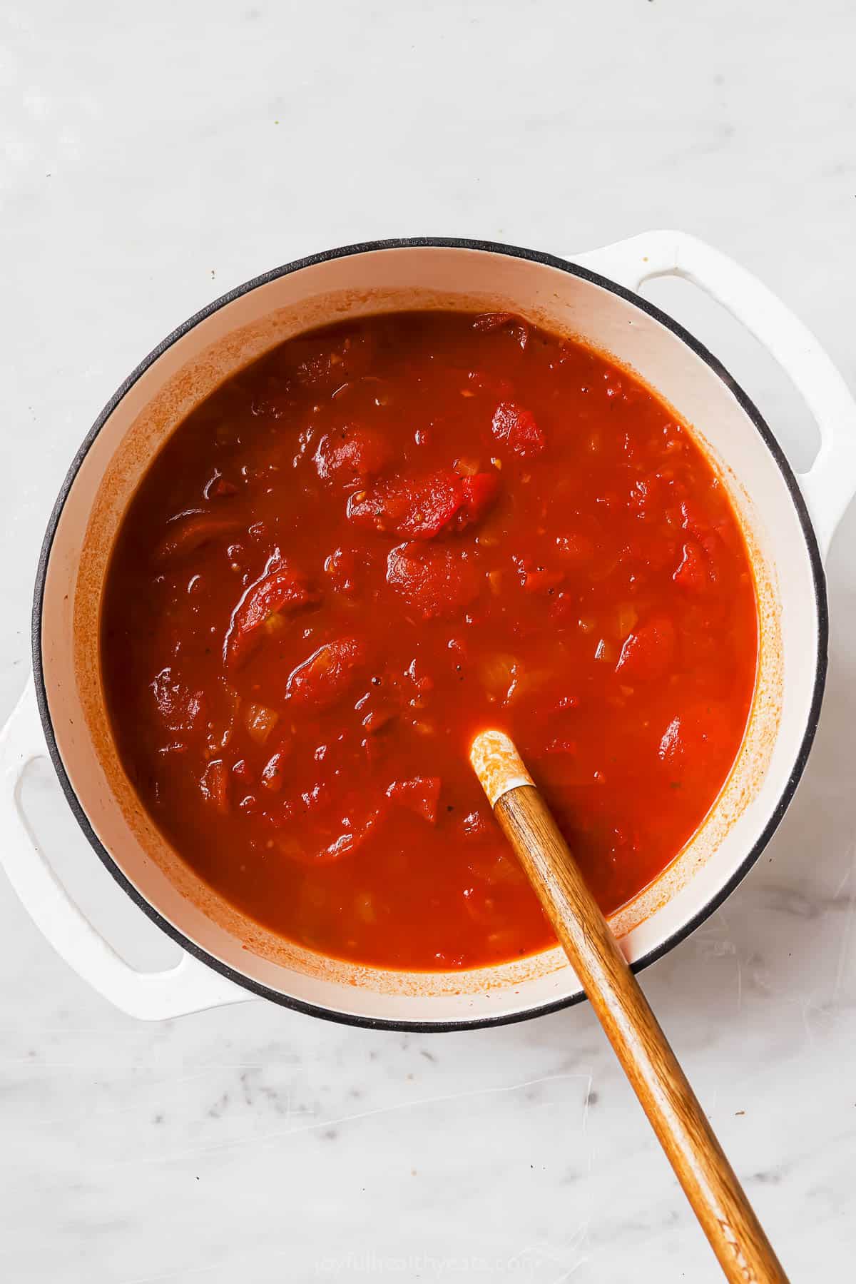 Adding the tomatoes to the pot. 