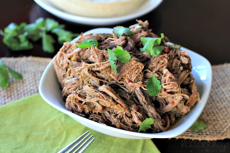 A bowl full of slow cooker barbacoa beef brisket on top of a wicker placemat