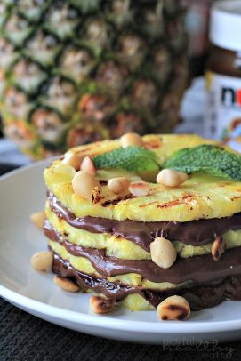 Layered pineapple slices and nutella on a plate with macadamia nuts