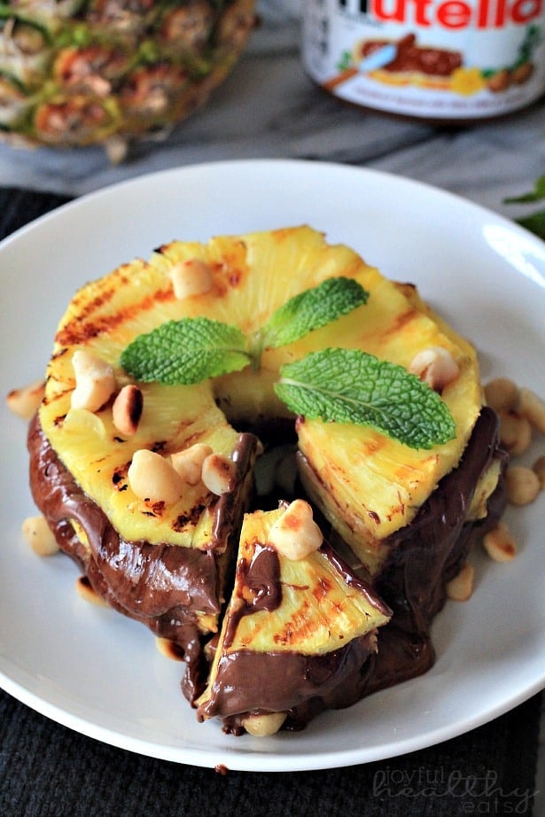 Top view of Grilled Pineapple with Nutella & Macadamia Nuts on a plate with a wedge cut