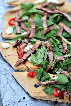 Homemade Pizza with Steak, Arugula, and Balsamic Reduction on tin foil