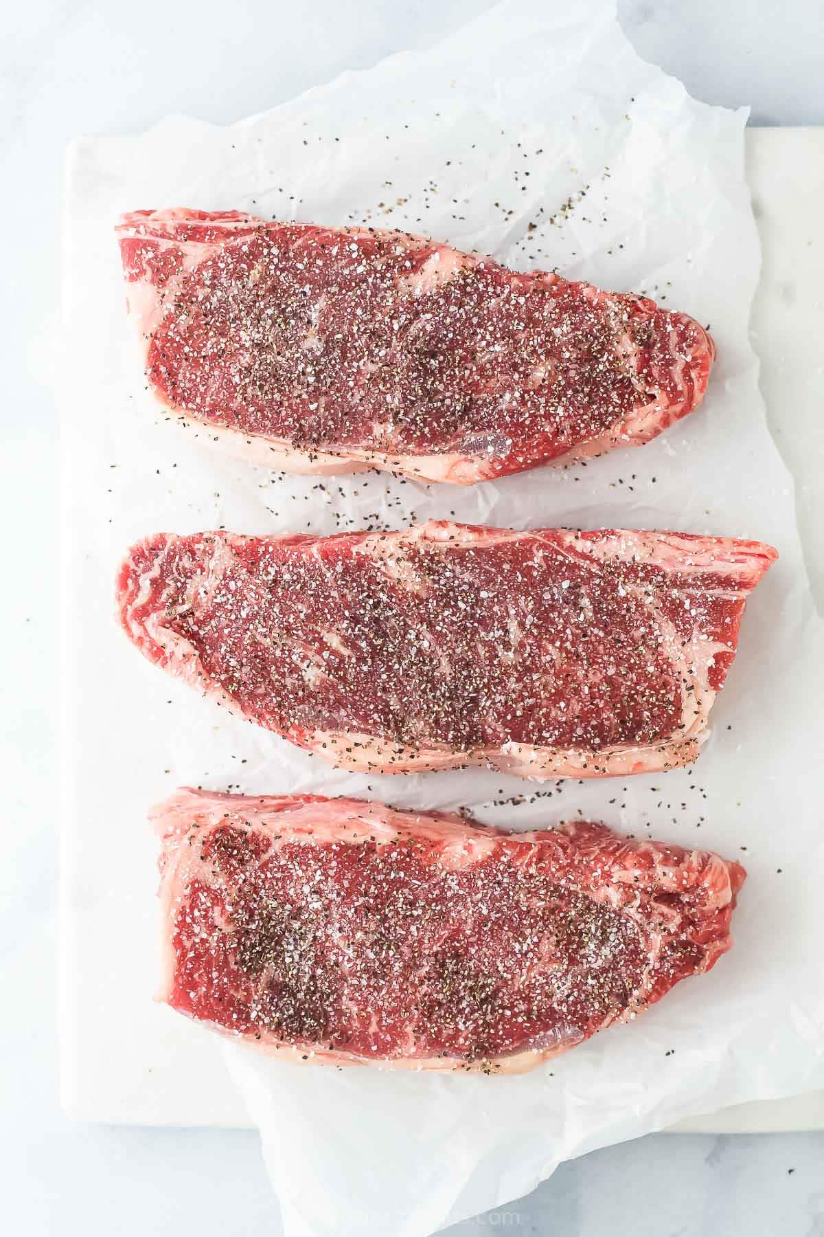 Season the raw steak with salt and pepper.