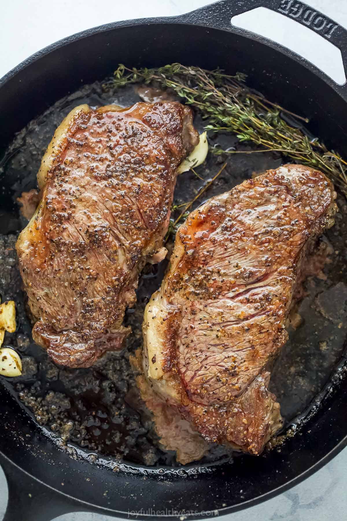 Place steak in skillet and add melted butter, garlic and thyme.