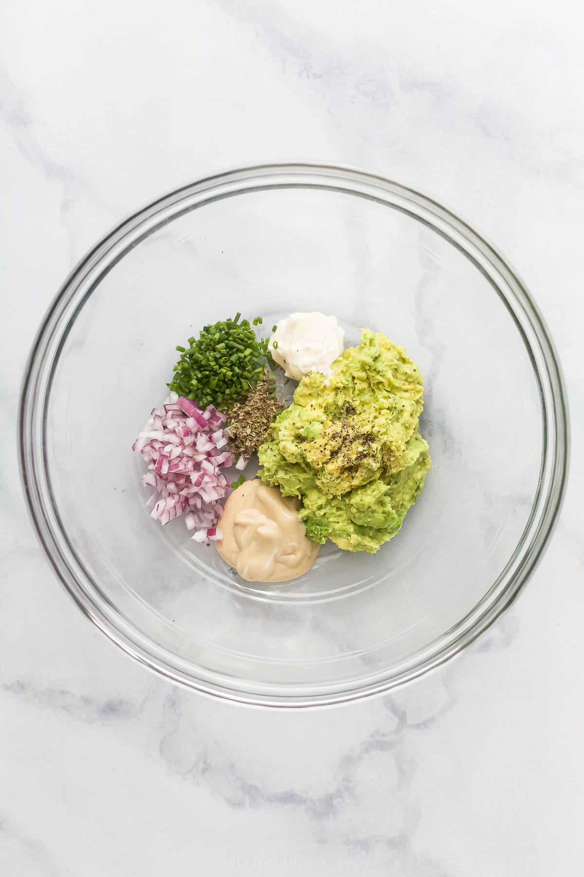 This Avocado Egg Salad is a healthy & satisfying salad made with less mayo! It's perfect for breakfast or lunch. various ingredients to make an avocado dressing like avocado, red onion, and chives.