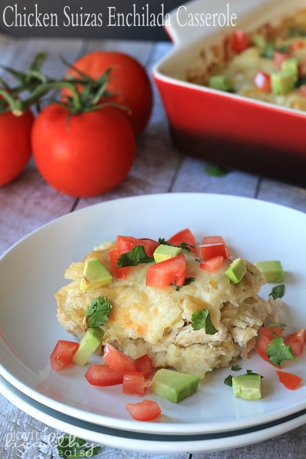 A serving of Chicken Suizas Enchilada Casserole on a plate topped with diced tomato and avocado