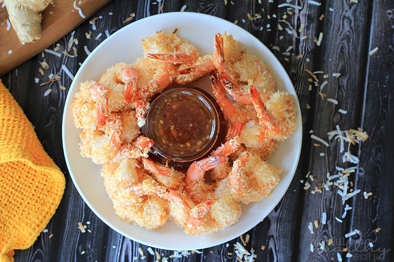 A Plate of Coconut Shrimp with Ginger Sauce on a Table Beside a Yellow Cloth