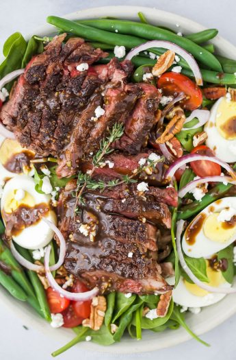closeup overhead photo of the ultimate ribeye steak salad with hardboiled eggs, tomatoes, onions