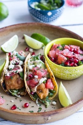 Two Baja fish tacos with a bowl of grapefruit salsa