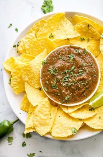 a plate filled with restaurant style salsa and chips