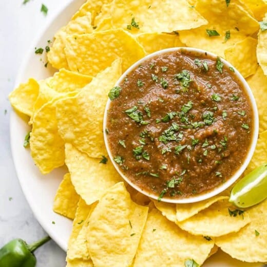 a plate filled with restaurant style salsa and chips