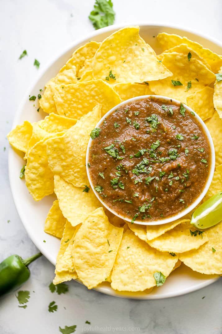 a plate filled with restaurant style salsa and chips