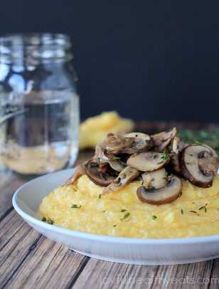 A bowl of creamy polenta topped with sliced mushrooms