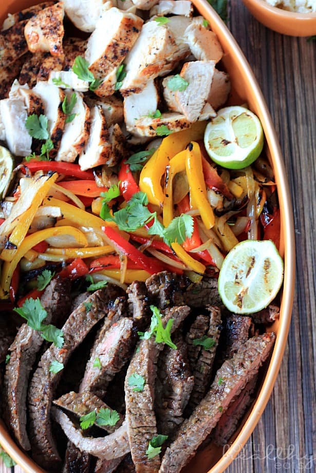 Sliced Grilled Fajita Skirt Steak, Sliced Grilled Chicken , Peppers and Onions on a platter