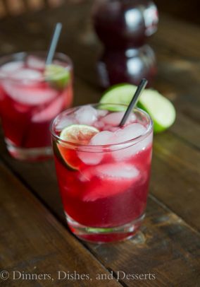 Pomegranate Margaritas in a short glass with ice and lime wedge