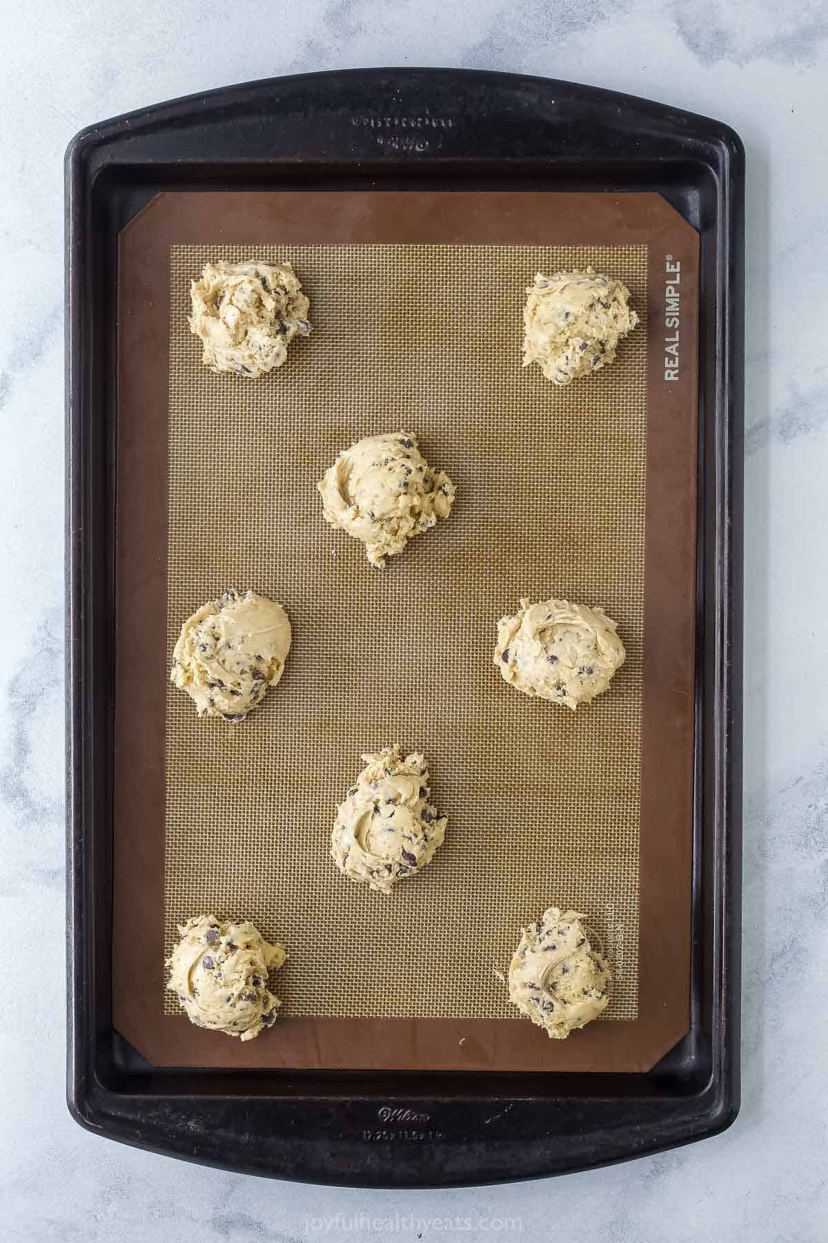 Overhead view of cookie dough on silpat-lined baking sheet