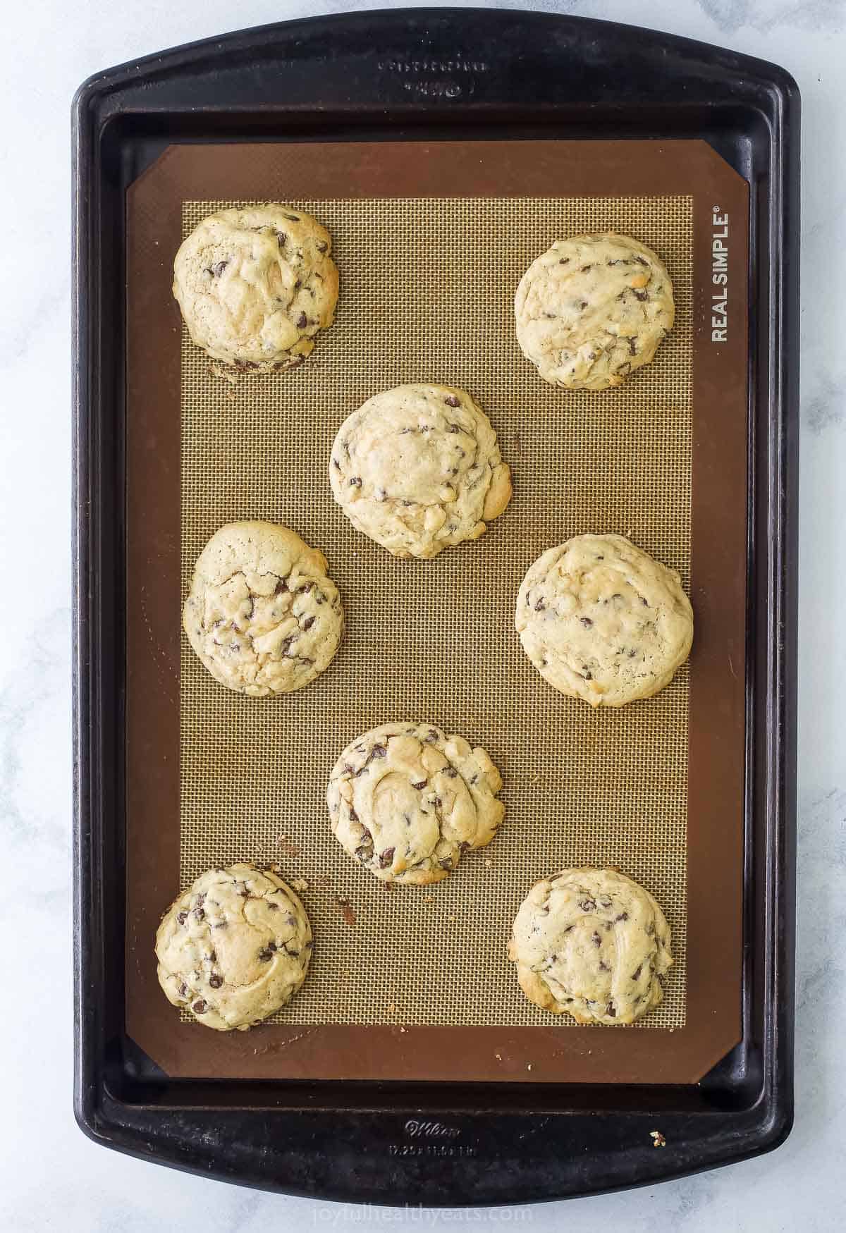 Overhead view of soft chocolate chip cookies on silpat-lined baking sheet