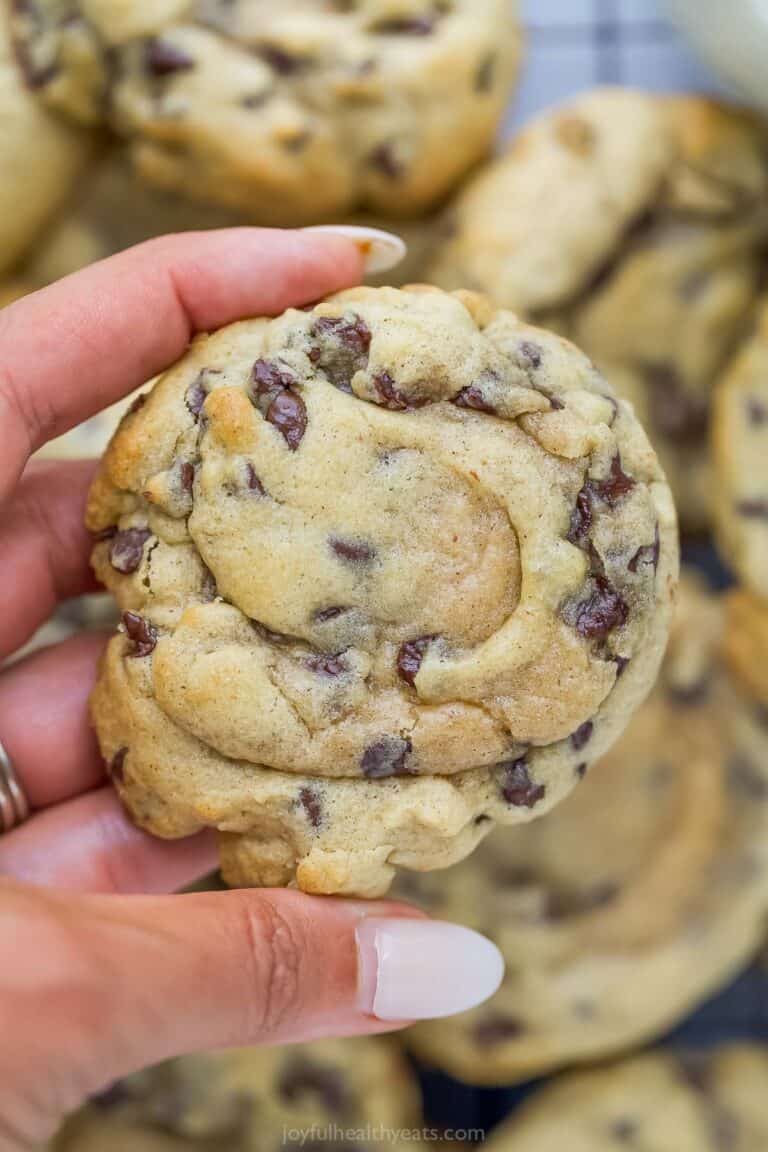 Hand holding soft chocolate chip cookie