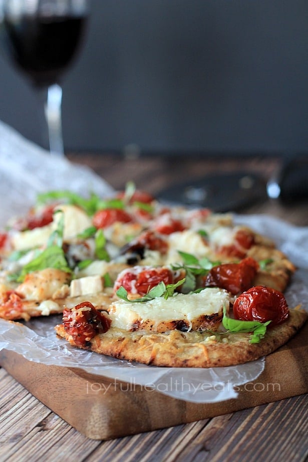 Side view of Grilled Chicken Margherita Pizza on parchment paper