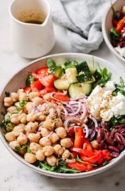 Mediterranean salad full of crunchy veggies with Greek vinaigrette in a bowl.
