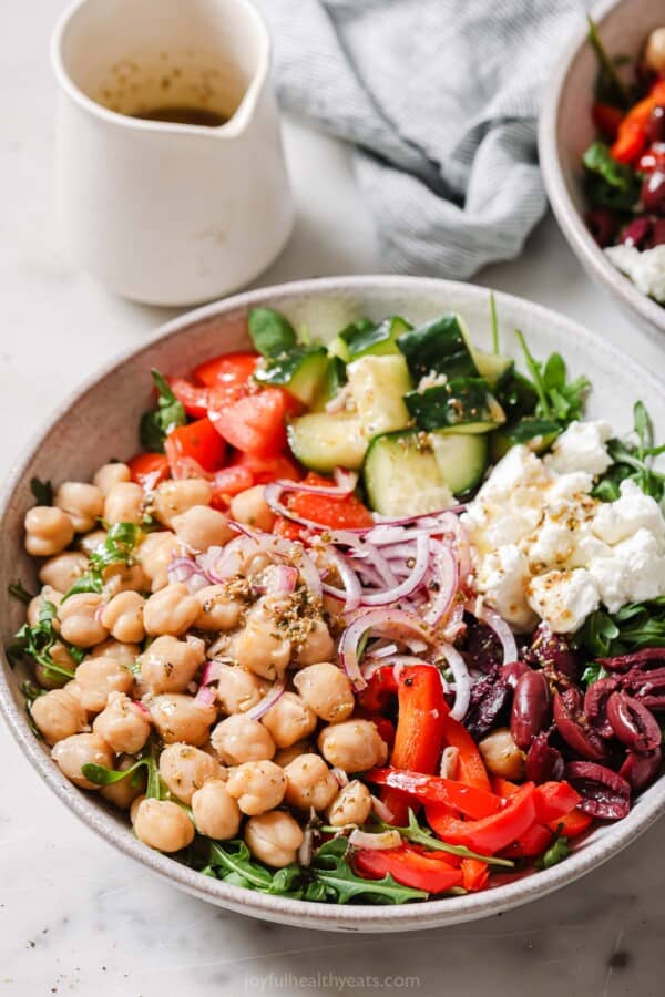 Mediterranean salad full of crunchy veggies with Greek vinaigrette in a bowl.