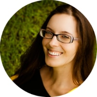 A circle portrait of a woman with dark straight hair and glasses